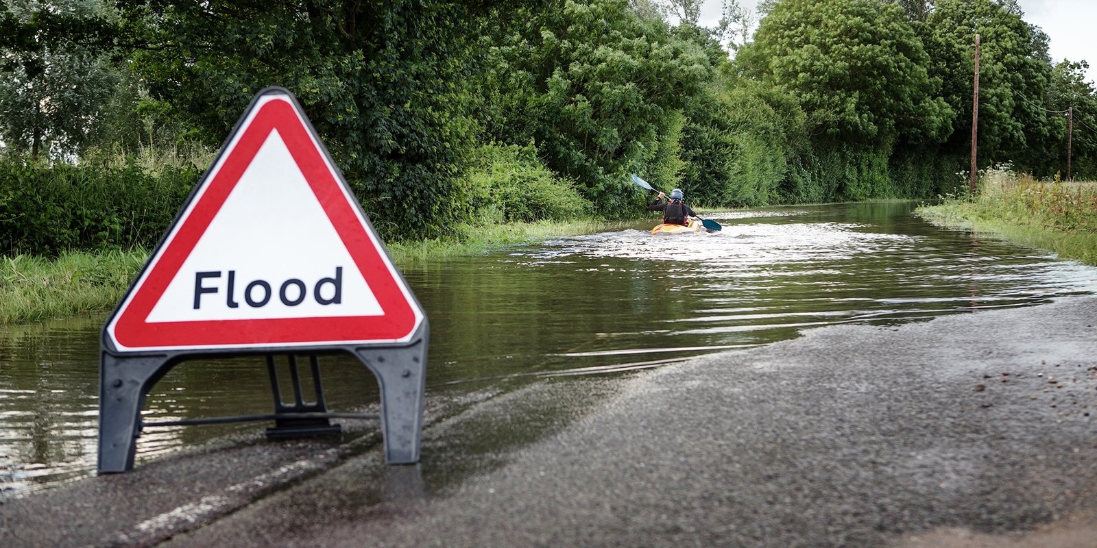 "Flooded neighborhood street in Westerville, Ohio representing the importance of flood insurance coverage provided by a local insurance company."