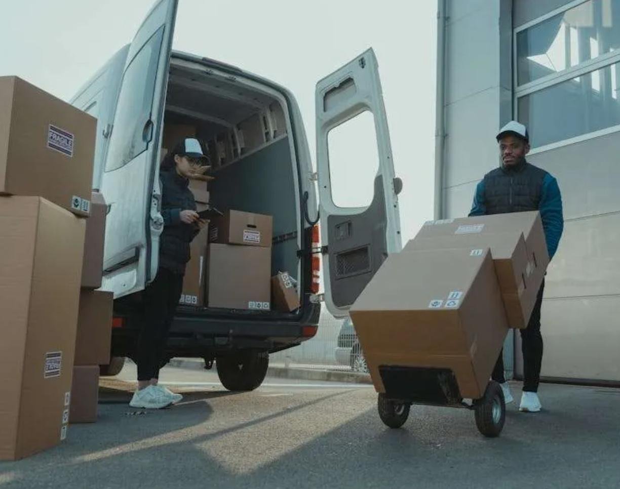 A white box truck parked beside a modern office building in Westerville, Ohio, representing comprehensive box truck insurance options offered by Insurance Company Westerville Ohio LLC.